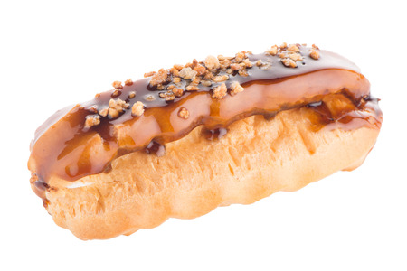 Eclair with caramel decoration on white reflective background.の写真素材