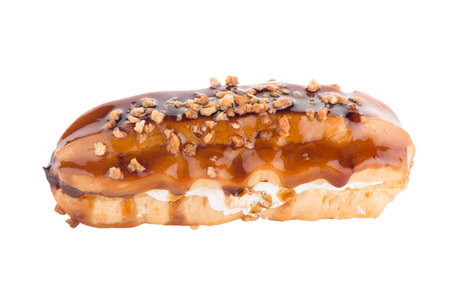 Eclair with caramel decoration on white reflective background.の写真素材