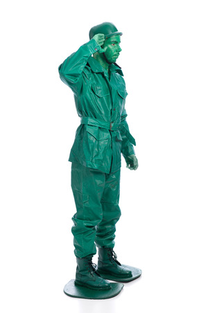 Man on a green toy soldier costume saluting isolated on white background.の写真素材