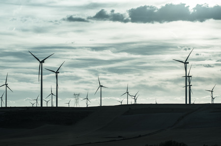 Backlit view of a group of mills for electric power generation