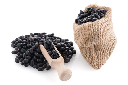 Black beans bag with wooden scoop on white background.の写真素材