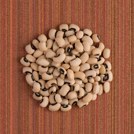 Top view of circle of white beans against red vinyl background.の写真素材