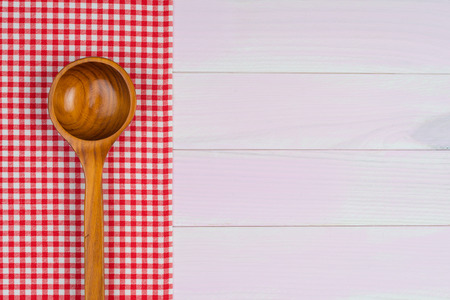 Kitchenware on white and red towel over wooden kitchen table. View from above.の写真素材