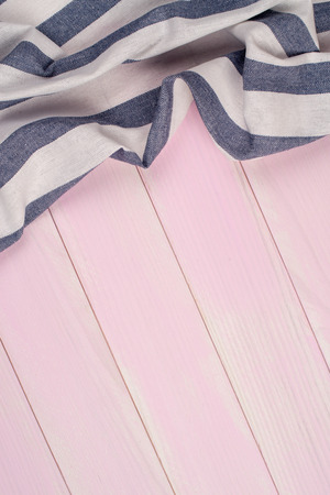 White and blue towel over wooden kitchen table. View from above.の写真素材