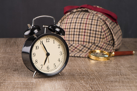 Deerstalker or Sherlock Hat and magnifying glass on Old Wooden table.の写真素材