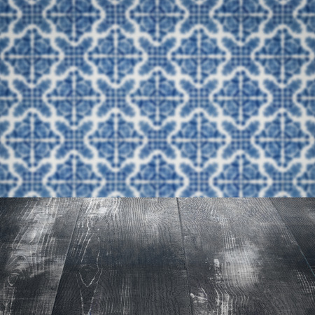 Empty wood table top and blur vintage ceramic tile pattern wall in background, Mock up template for...