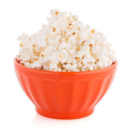 Popcorn in a orange bowl on a white backgroundの写真素材
