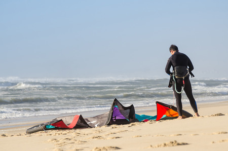 Kitesurfer prepating his equipment on a beautiful sunset at the beach.の写真素材