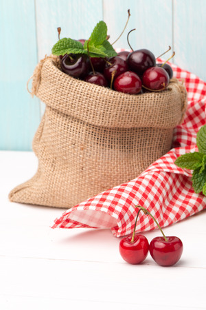 Cherries in small bag on the wooden table.の写真素材