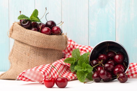 Cherries in small bag on the wooden table.の写真素材