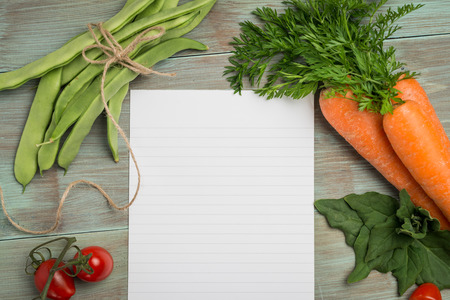 Blank white paper and fresh colorful vegetables on kitchen tableの写真素材