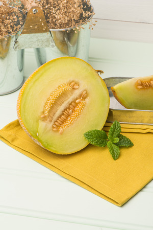 Juicy honeydew melon on a wooden table background.の写真素材