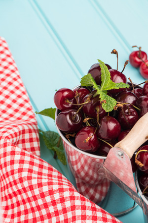 Ripe red cherries in blue wooden table background.の写真素材