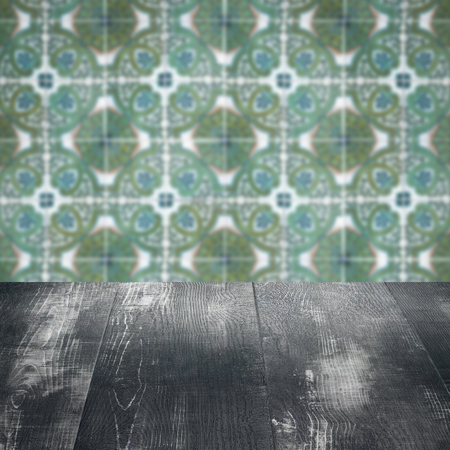 Empty wood table top and blur vintage ceramic tile pattern wall in background, Mock up template for...