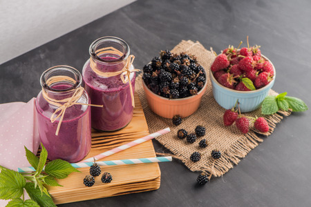 Fresh red fruits smoothie on vintage decorated  wooden table.