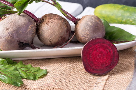 Beetroots on white painted rustic wooden table with slate background.