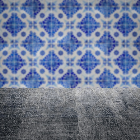 Empty wood table top and blur vintage ceramic tile pattern wall in background, Mock up template for...
