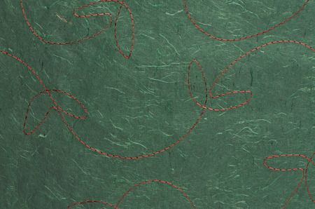 Closeup detail of stitched green recycled paper.