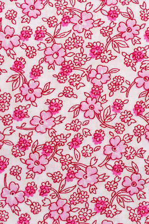 White and pink fabric with floral pattern background.