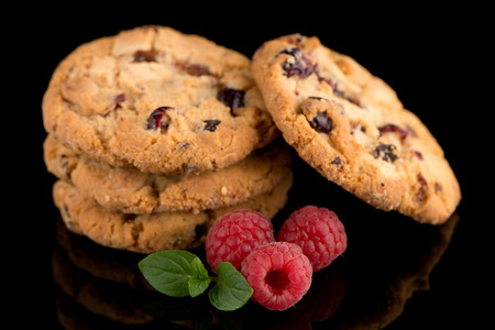 Dried fruits chip cookies and raspberries isolated on black background.の写真素材