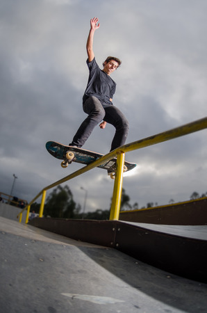 Skateboarder doing a board slide over the rail at the skate park.の写真素材