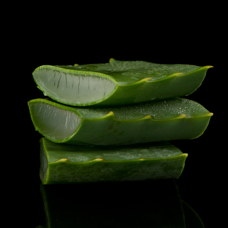 Sliced aloe leaf and water drops isolated on black background.の写真素材