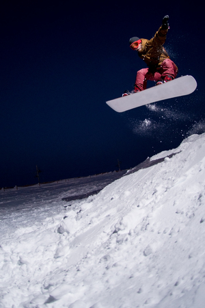 Snowboarder jumping at night.の写真素材