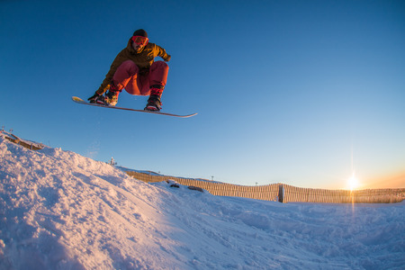 Young man snowboarding in the mountains.の写真素材
