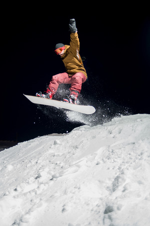 Snowboarder jumping at night.の写真素材