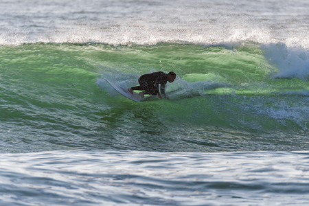 Long boarder surfing the waves at sunset in Portugal.の写真素材