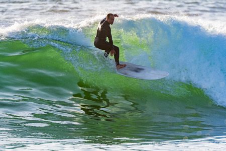 Long boarder surfing the waves at sunset in Portugal.の写真素材