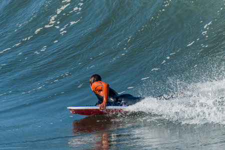 Bodyboarder in action on the ocean waves on a sunny day.の写真素材