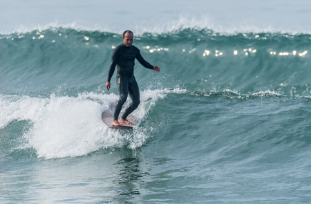 Surfer in action on the ocean waves on a sunny day.
