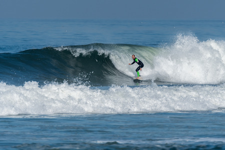 Surfer in action on the ocean waves on a sunny day.