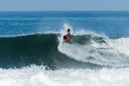 Bodyboarder in action on the ocean waves on a sunny day.