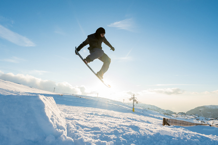 Snowboarder executing a radical jump against blue sky.の写真素材