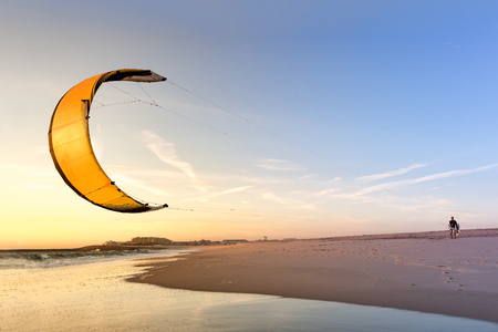 Kite surfer watching the waves at sunset in Portugal.の写真素材