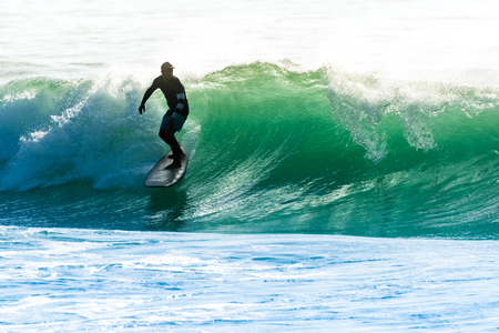 Surfer in action on the ocean waves on a sunny day.