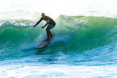 Surfer in action on the ocean waves on a sunny day.