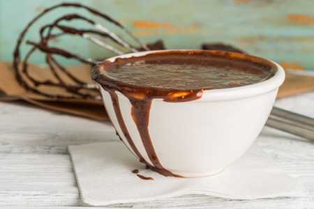 Chocolate on egg beater and chocolate mouuse on wooden table topの写真素材