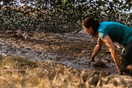 ESTARREJA, PORTUGAL - SEPTEMBER 23: Athletes crawling through mud at the Biorace on september 23, 2017 in Estarreja, Portugal.のeditorial素材