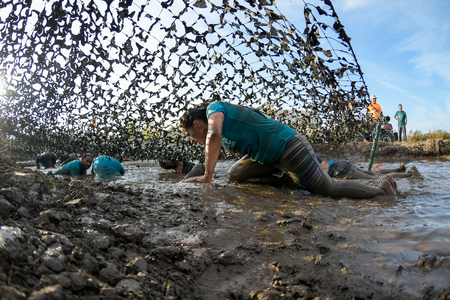 ESTARREJA, PORTUGAL - SEPTEMBER 23: Athletes crawling through mud at the Biorace on september 23,...