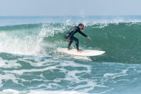 Surfer in action with a small action camera on the ocean waves on a sunny day.の写真素材