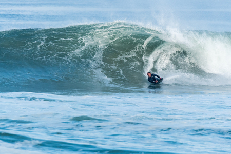 Bodyboarder surfing ocean wave on a sunny day.の写真素材