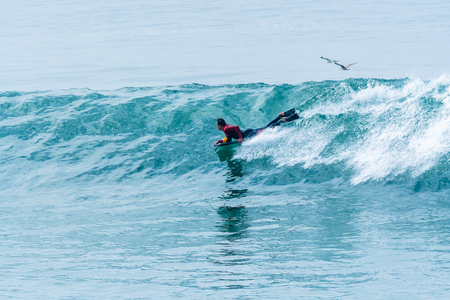 Bodyboarder surfing ocean wave on a sunny day.の写真素材
