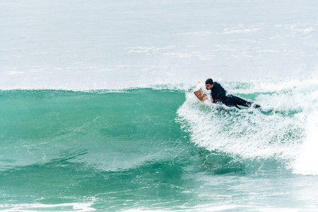 Bodyboarder surfing ocean wave on a sunny day.の写真素材
