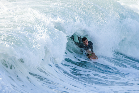 Bodyboarder surfing ocean wave on a sunny day.の写真素材