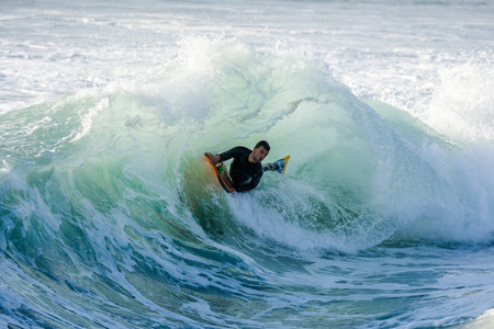 Bodyboarder surfing ocean wave on a sunny day.の写真素材