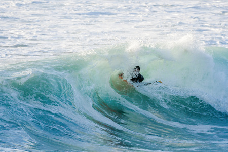 Bodyboarder surfing ocean wave on a sunny day.の写真素材