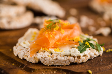 Delicious smoked salmon and cream cheese on rice bread toasts.の写真素材